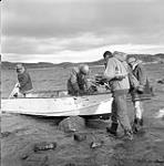 [Men loading a boat with supplies] [between 1956-1960]
