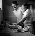 [Barbara Hinds (left) and a girl cooking in a kitchen] [between 1956-1960]
