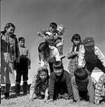 [Children and their instructor making a human pyramid, Kinngait, Nunavut] [between 1956-1960]