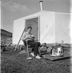 [Barbara Hinds drinking from a tea cup outside a tent] [between 1956-1960]
