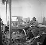 [Mackenzie Porter reading inside a tent] [between 1956-1960]