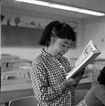 [Girl reading aloud from a book in a classroom] [between 1956-1960]