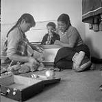 [Sam and two girls playing with toys, Kinngait, Nunavut] [between 1956-1960]