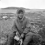 [Elijah seated outside holding a paintbrush, Iqaluit, Nunavut] [between 1956-1960]