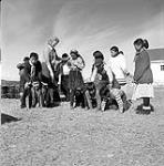 [Children making a human pyramid while their instructor supervises, Kinngait, Nunavut] [between 1956-1960]