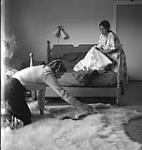 [Barbara Hinds (left) with Nepitia (right) in a bedroom, Kinngait, Nunavut] [between 1956-1960]