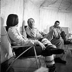 [Three people sitting in a tent] [between 1956-1960]