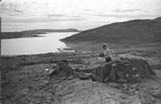 [Barbara Hinds examining a rock] [between 1956-1960]