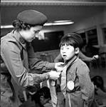 [Kathy Thompson helping a young Brownie with her tie, Iqaluit, Nunavut] 1960