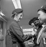 [A Girl Guide receiving a new badge from Mrs. Delaute, Iqaluit, Nunavut] 1960