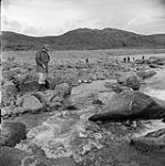 [Mackenzie Porter (left) fishing in a small creek, Iqaluit, Nunavut] 1960