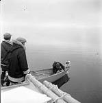 [Isa (left), Spyglassie (middle) and Mike (right) on a boat, Iqaluit, Nunavut] 1960