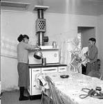 [Two women and a child in a kitchen, Niaqunngut, Iqaluit, Nunavut] 1960