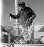 [Man standing on a boat named Peterhead, Iqaluit, Nunavut] 1960
