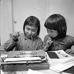 [Two girls working on an art project, Iqaluit, Nunavut] 1960