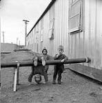 [Children playing on a waste water pipe, Iqaluit, Nunavut] 1960