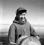 [Mosha Michael steering a boat named Peterhead, Iqaluit, Nunavut] 1960