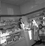 [Woman and girl shopping in the Hudson's Bay Company ladies store, Iqaluit, Nunavut] 1960