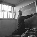 [Gerry Mahoney writing on a chalkboard, Iqaluit, Nunavut] 1960
