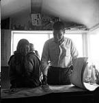 [James Houston and a woman looking at artwork, Kinngait, Nunavut] 1960