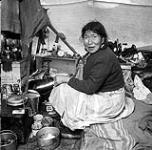 [Eleeshushe Parr sits in a ten, Kinngait, Nunavut] [Woman sitting inside a tent, Kinngait, Nunavut] 1960