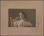 Portrait of Madge Macbeth sitting in an ornate wicker chair ca. 1895.
