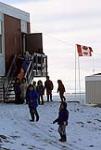 Group in front of Canadian flag, Pond Inlet 1979.