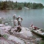 Four fishermen prepare a meal in the Lake of the Woods district of Ontario juillet 1950
