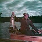 One fishermen and his catch in the Lake of the Woods district of Ontario July 1950