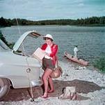 Shirley Emerson, de Saint John, au Nouveau-Brunswick, prépare son équipement pour aller pêcher avec son père, R.B. Emerson, au lac Bennett, dans le parc national de Fundy juillet 1950