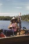 Woman in canoe landing a fish in the Lake of the Woods near Nestor Falls, Ontario juillet 1950