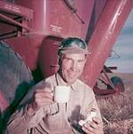 Howard Robbins, one of original members of Matador Cooperative Famer, has quick coffee during harvesting operations 1952