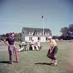 Deux hommes et deux femmes jouent au golf, dans les Maritimes juillet 1953