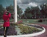 RCMP officer blowing his trumpet at the RCMP training school, Regina, Saskatchewan August 1957