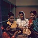 « Soirée asiatique » à la Maison d'amitié, Ottawa - Rehana Imdadullah, Hasna Aziz, Madame Imdadullah et Madame Azeez regardant un serpent jouet qui sera utilisé dans une danse du serpent 1963