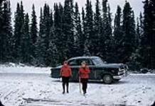 Anna et Marguerite s'éloignant d'une voiture, avec une pelle à la main - parc des Laurentides, Québec [entre 1955-1963]