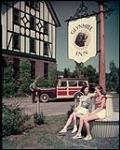 Glynmill Inn, at Corner Brook, Newfoundland. Resting at base of sign are Eileen O'Rourke and Rita Kennedy, of Corner Brook. juillet 1949.