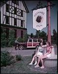 Glynmill Inn, at Corner Brook, Newfoundland. Resting at base of sign are Eileen O'Rourke and Rita Kennedy, of Corner Brook. juillet 1949.