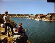 Ruth and John Wilson of Clinton, Ont, look out over the harbour fron the lookout at Tobermory, at the tip of the Bruce Peninsula. 1949.