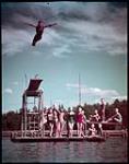 Robert Foley of Regina, Sask, practices diving from the three meter board at Waskesiu, Prince Albert National Park. juillet 1950.