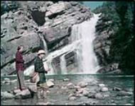 Trout fishing at foot of Cameron Creek Falls, Waterton Lakes National Park, Alta. août 1950.