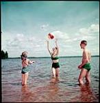 Playing beach ball at the tourist resort Gilwinkee Lodge on Golden Lake, Ontario. juillet 1951.