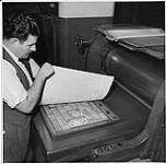 Globe and Mail, workers in the newspaper rooms, Toronto, man showing typeset plate [ca 1939-1951]