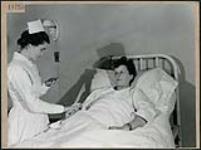 Une infirmière crie s'occupe d'une patiente à l'Hôpital Civic d'Ottawa March 1945