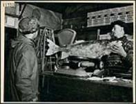 Chris Olsen weighing thirty-seven pounds of frozen whitefish, Lac la Ronge March 1945