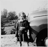 Ann MacDonald appuyée sur une voiture [1945]