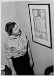 Dorothy Ann MacDonald regardant une affiche calligraphique [1960]