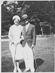 Wilson P. MacDonald and a woman holding golf clubs [1926]