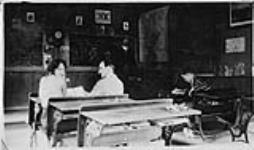 Wilson P. MacDonald and a woman sitting at a desk in a classroom [1926]