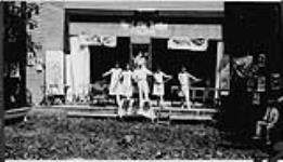 Wilson P. MacDonald et quatre femmes répétant sur une estrade en plein air [1925]